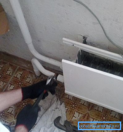 Demontering av den gamle radiatoren med nøkler Demontering av den gamle radiatoren med nøkler