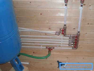 Samlerordningen for vannforsyning i et privat hus med egne hender under forsamlingsprosessen. Samlerordningen for vannforsyning i et privat hus med egne hender under forsamlingsprosessen.