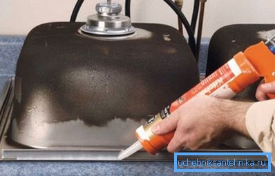 Påfør silikon på innsiden av et kjøkkenvaske i rustfritt stål før du monterer det i benkeplaten Påfør silikon på innsiden av et kjøkkenvaske i rustfritt stål før du monterer det i benkeplaten