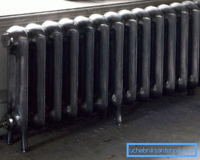 Stasjonær gulv støpejern radiator installert under vinduet Stasjonær gulv støpejern radiator installert under vinduet